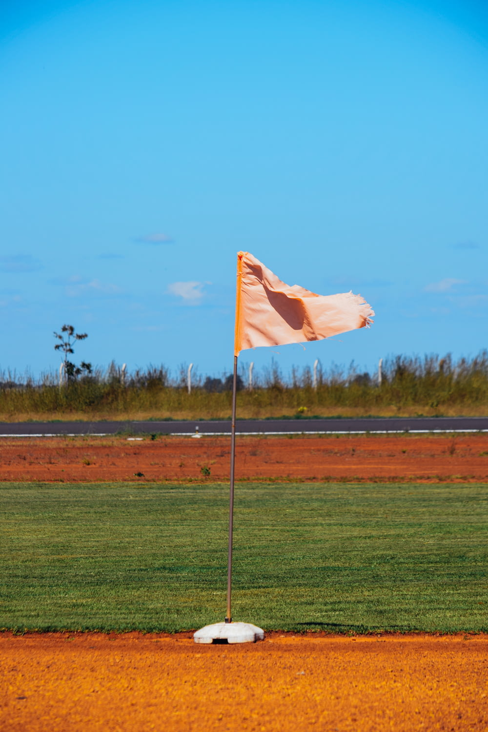 una bandera en un campo de béisbol con una base de tierra