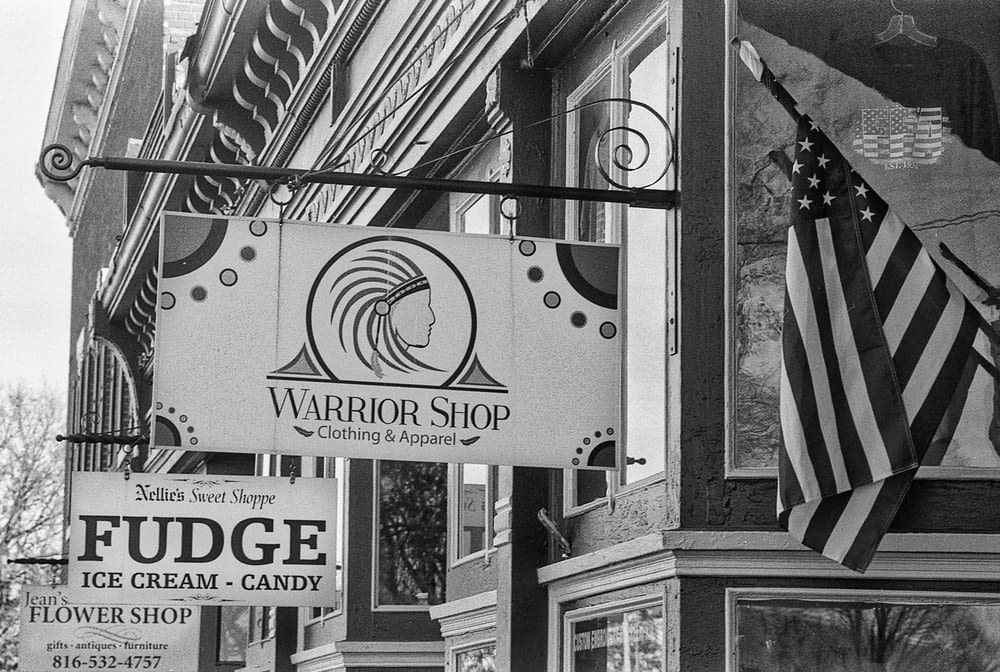 a black and white photo of a building with a sign for fudge ice cream