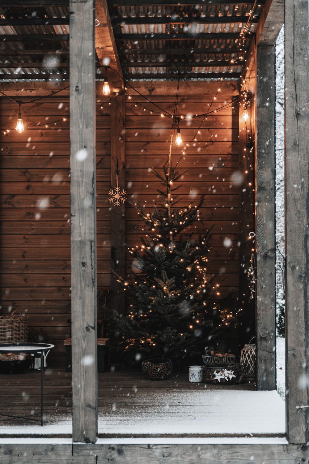 a small christmas tree in the corner of a porch