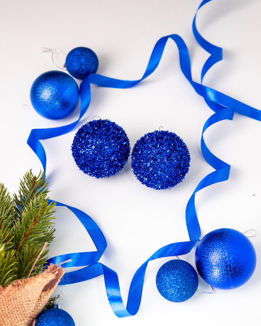 a blue christmas ornament and two blue balls on a white background