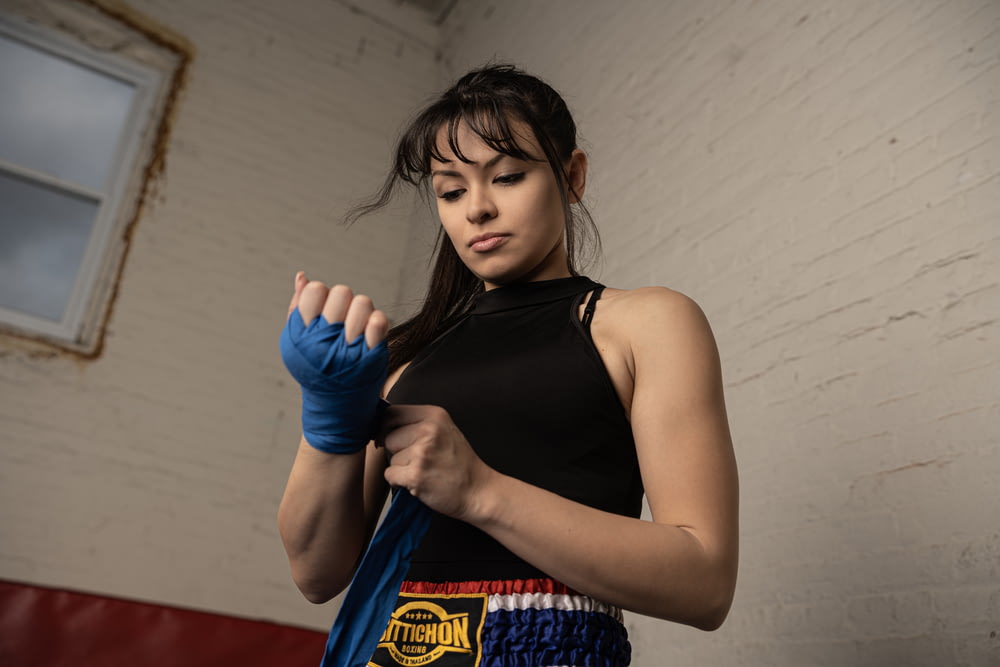a woman in a black top and blue gloves
