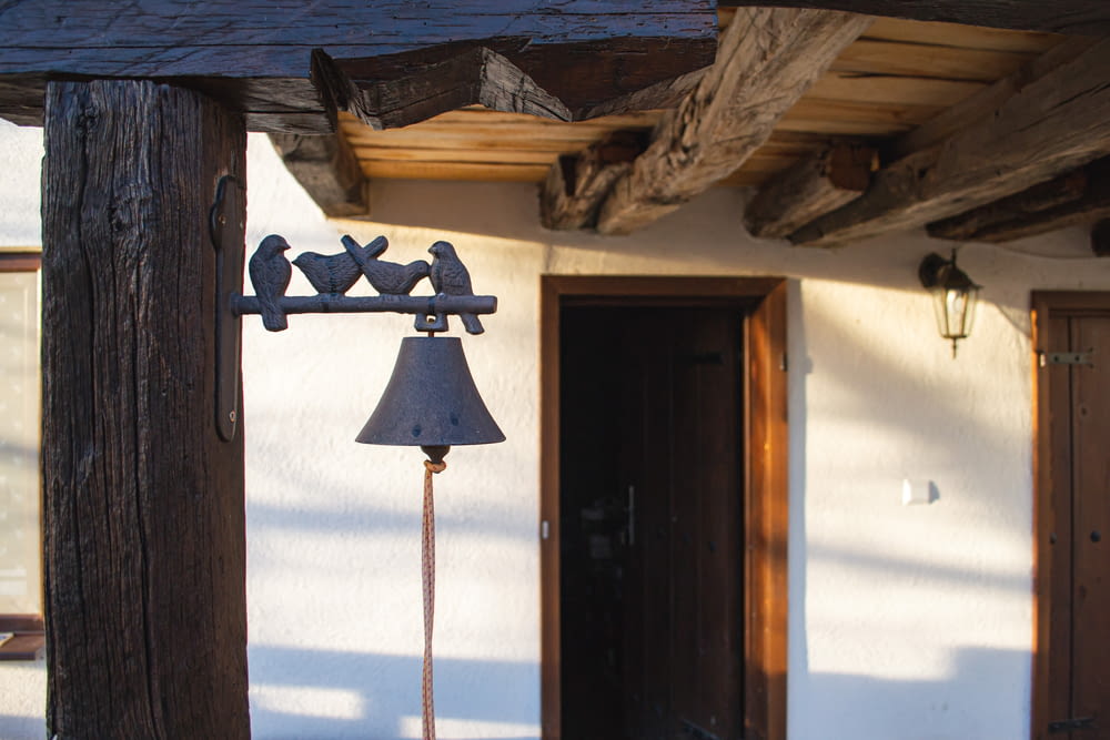 a bell on a pole in front of a house