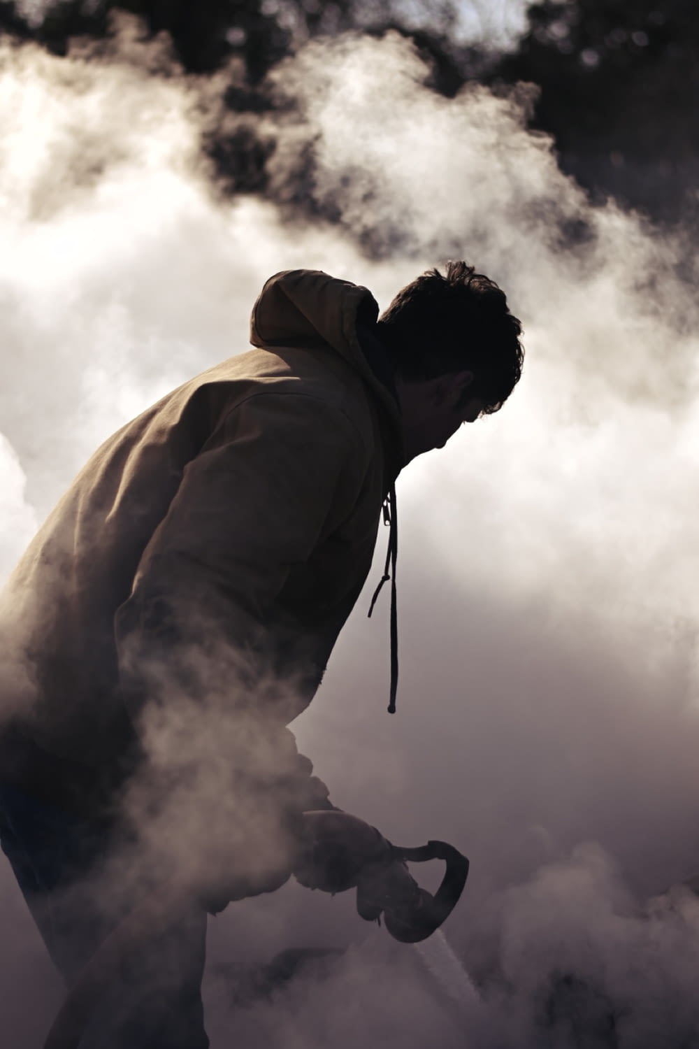 a man walking through a cloud of smoke
