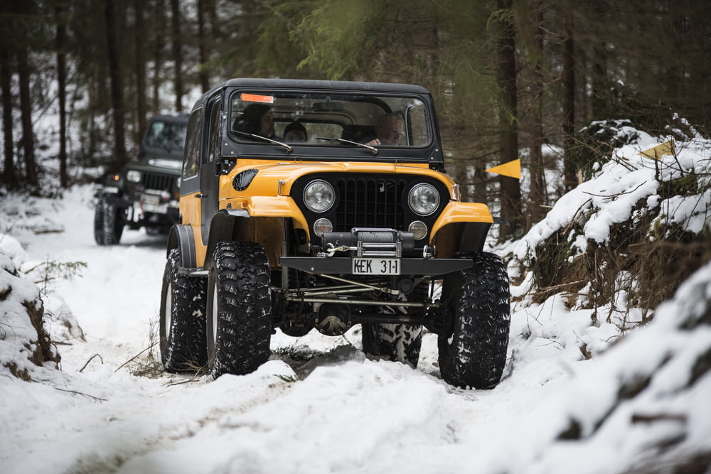 Un jeep conduciendo a través de la nieve en el bosque