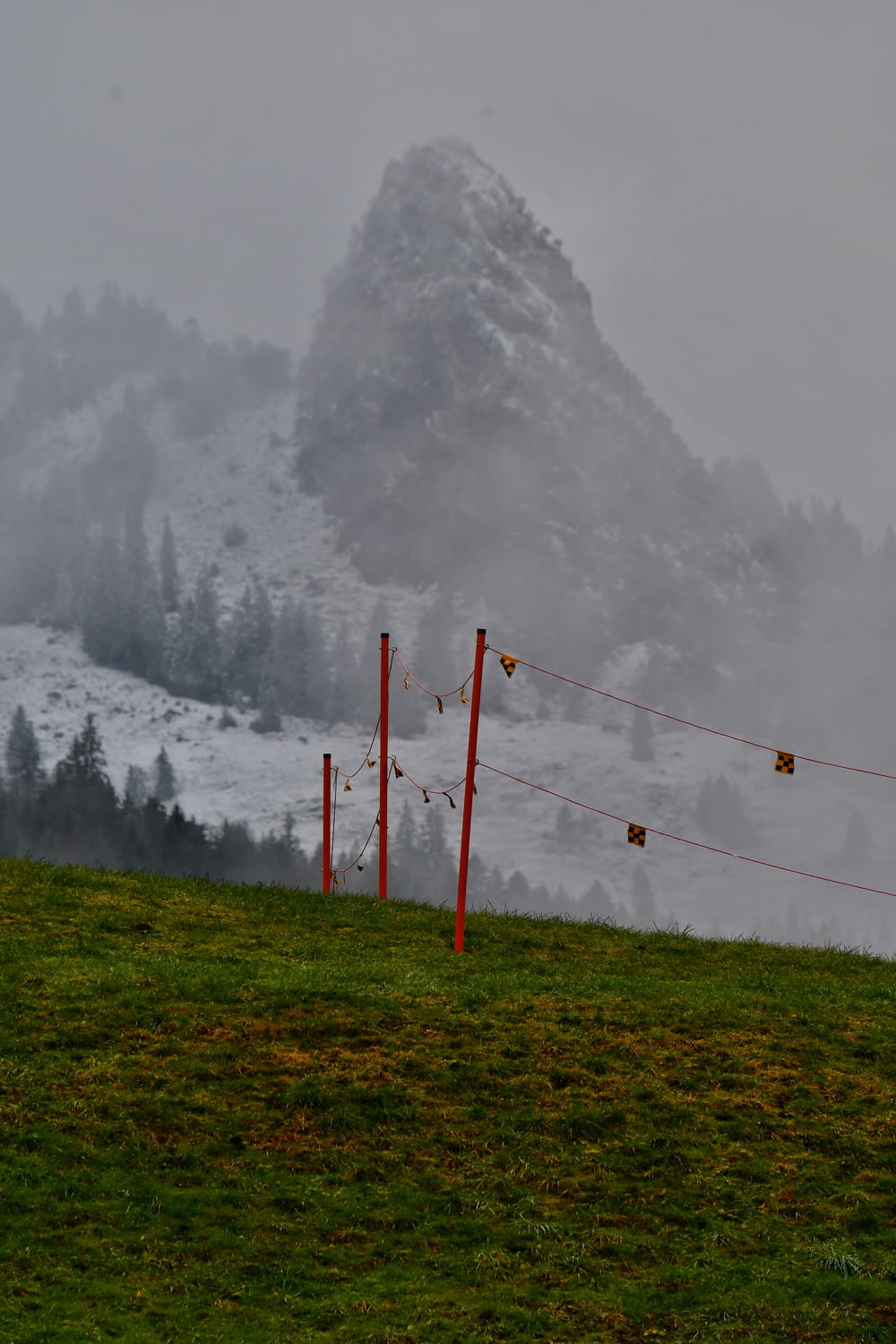 a foggy mountain with a red fence in the foreground