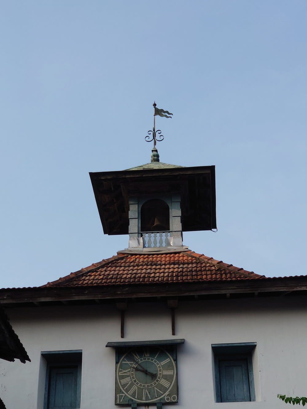 a clock tower with a weather vane on top of it