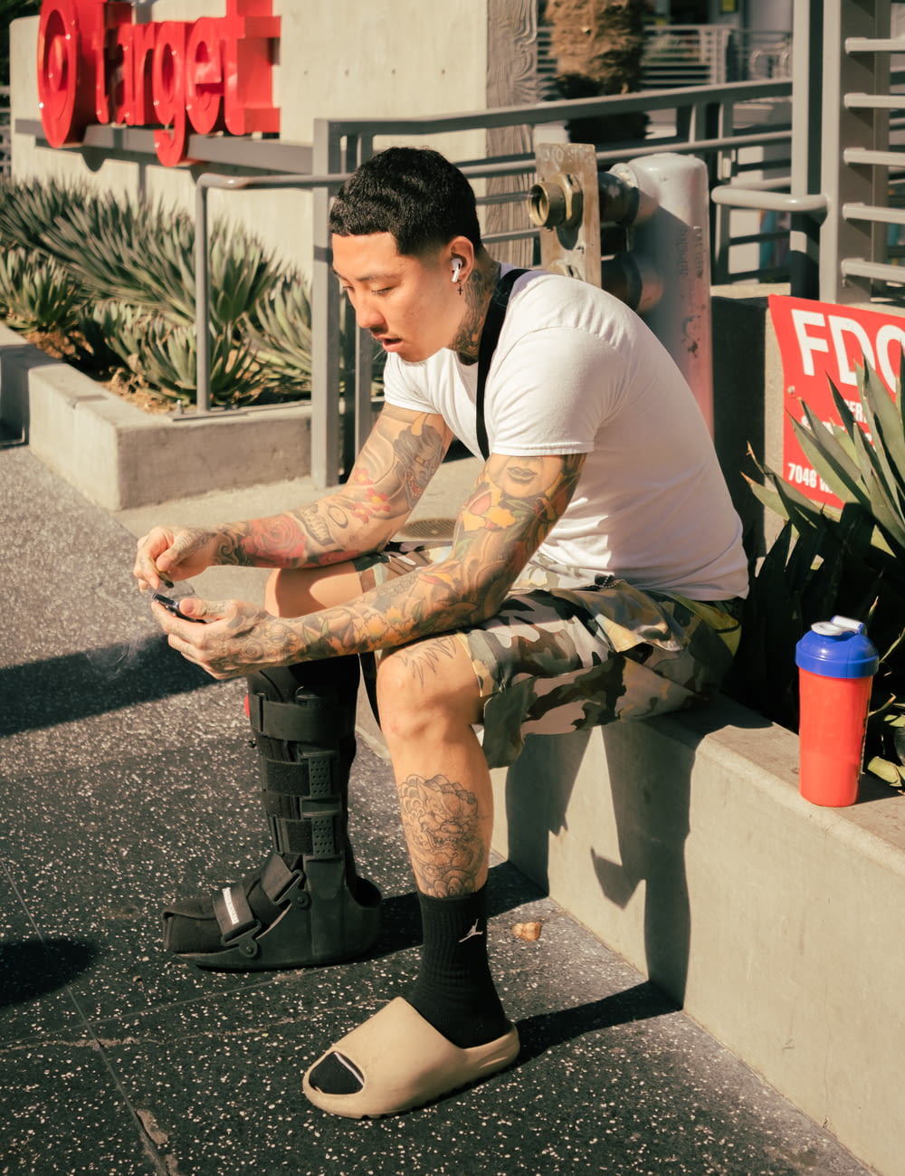 a man with tattoos sitting on a bench