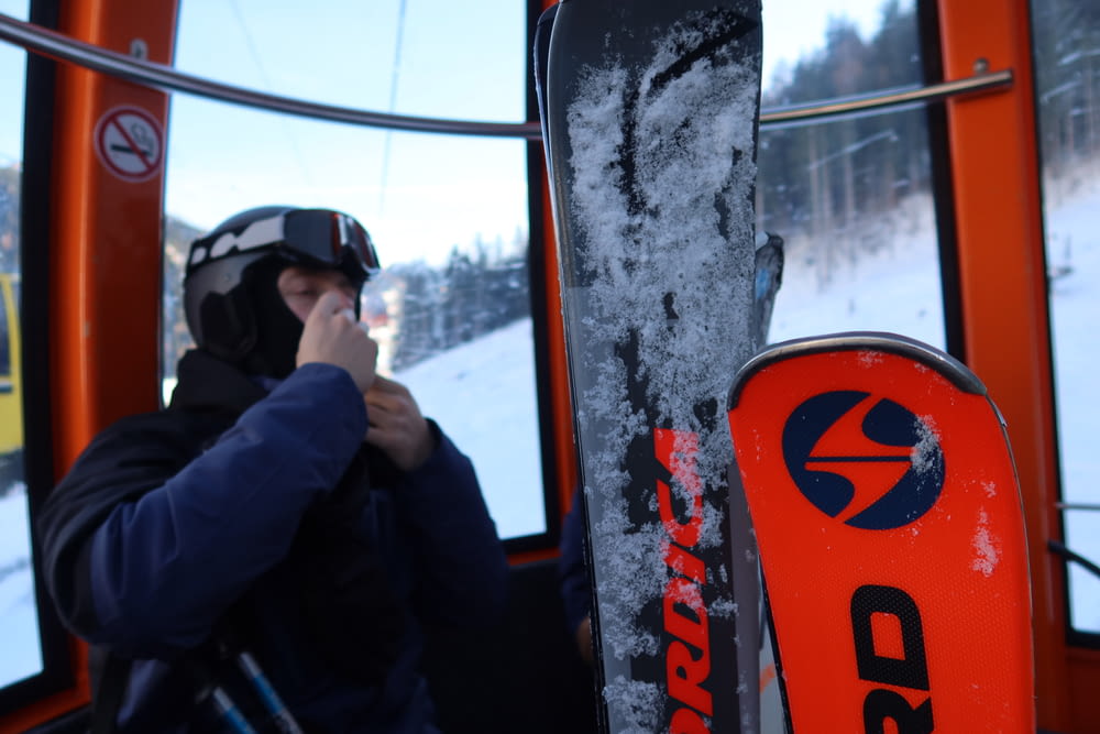a person on a ski lift with a snowboard