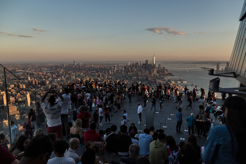 a crowd of people standing on top of a tall building