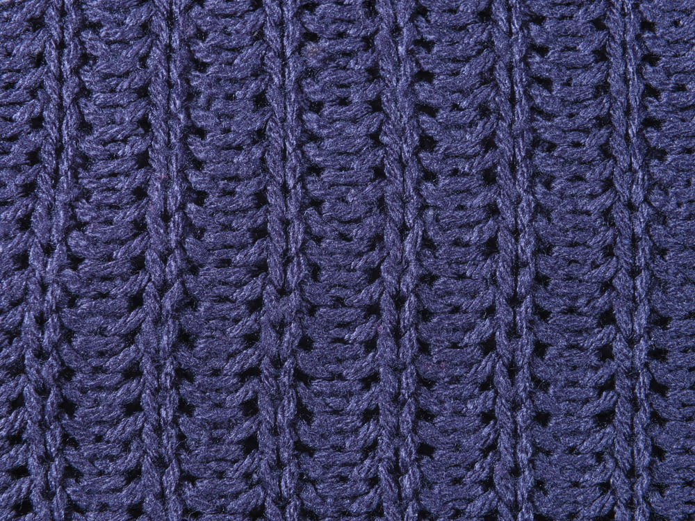 a close up of a blue knitted blanket