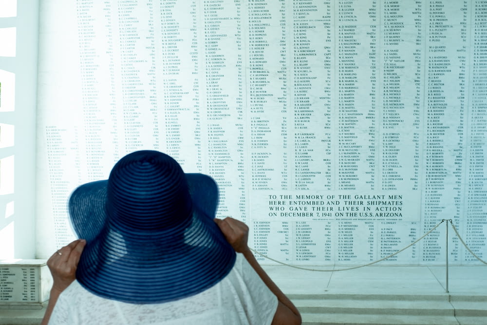 a woman wearing a blue hat in front of a wall