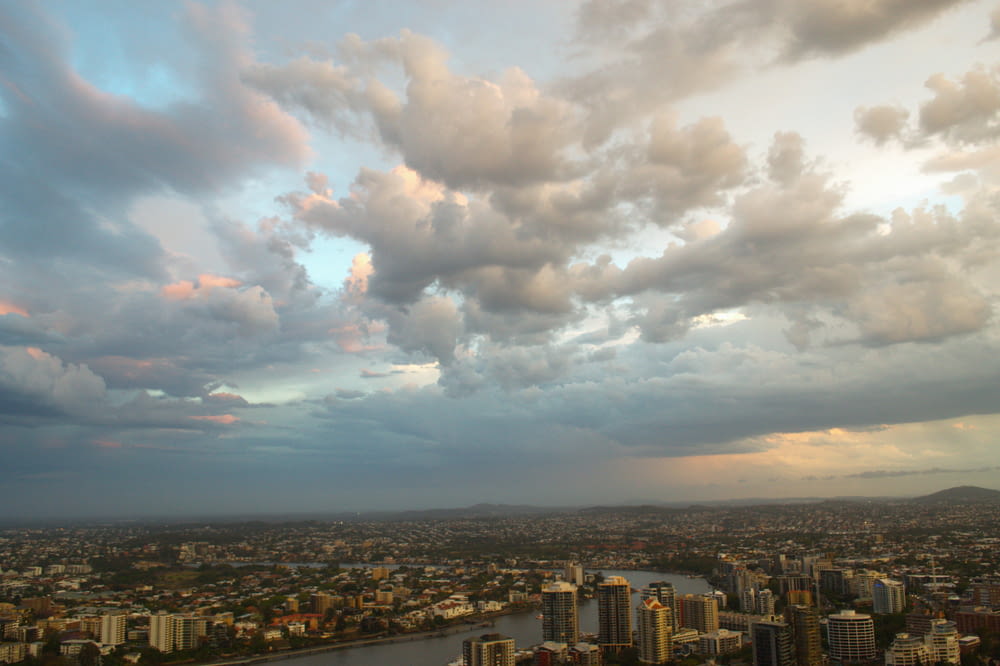 a cloudy sky over a city and a body of water