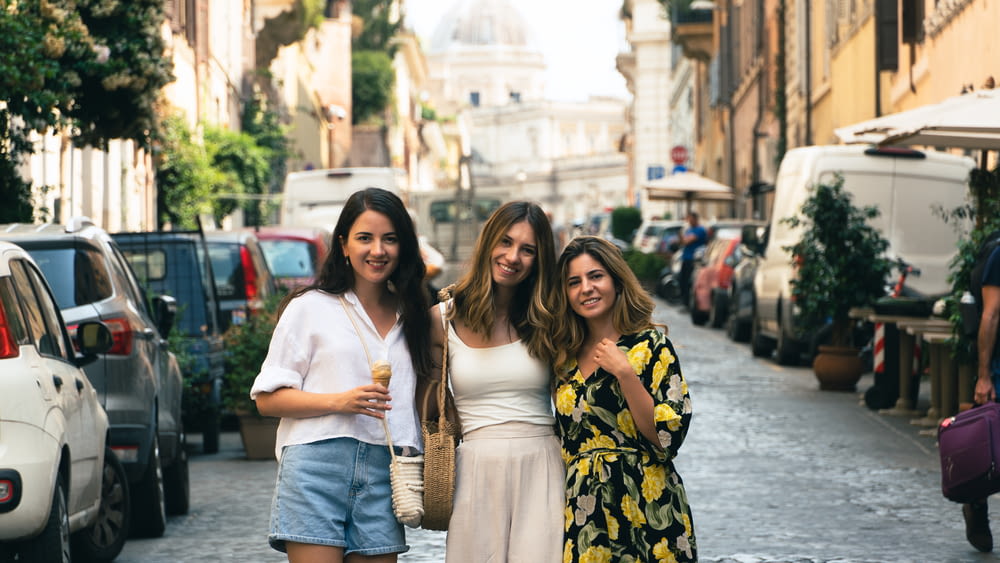 three women are standing in the middle of a street
