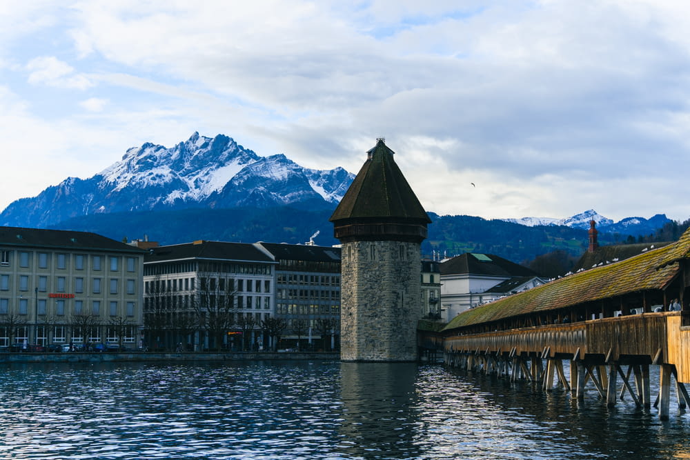 a large body of water with buildings and mountains in the background