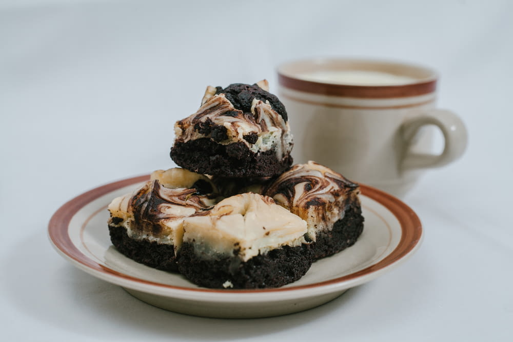 a white plate topped with brownies and a cup of coffee