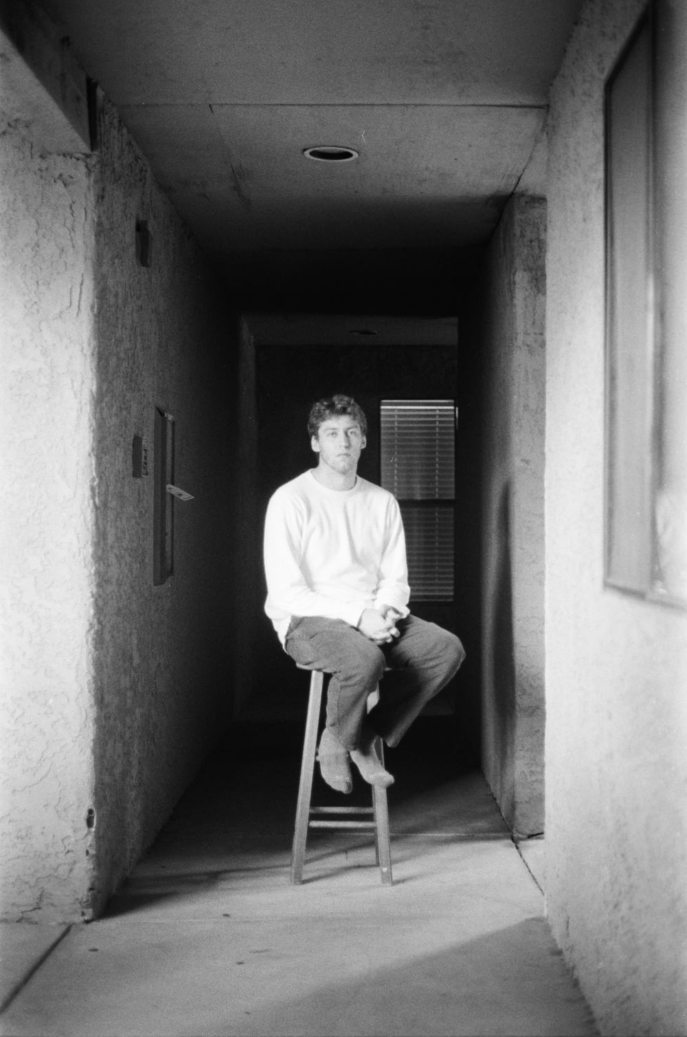 a man sitting on a stool in a hallway