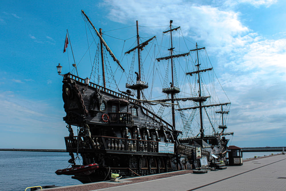 a large wooden pirate ship docked at a pier