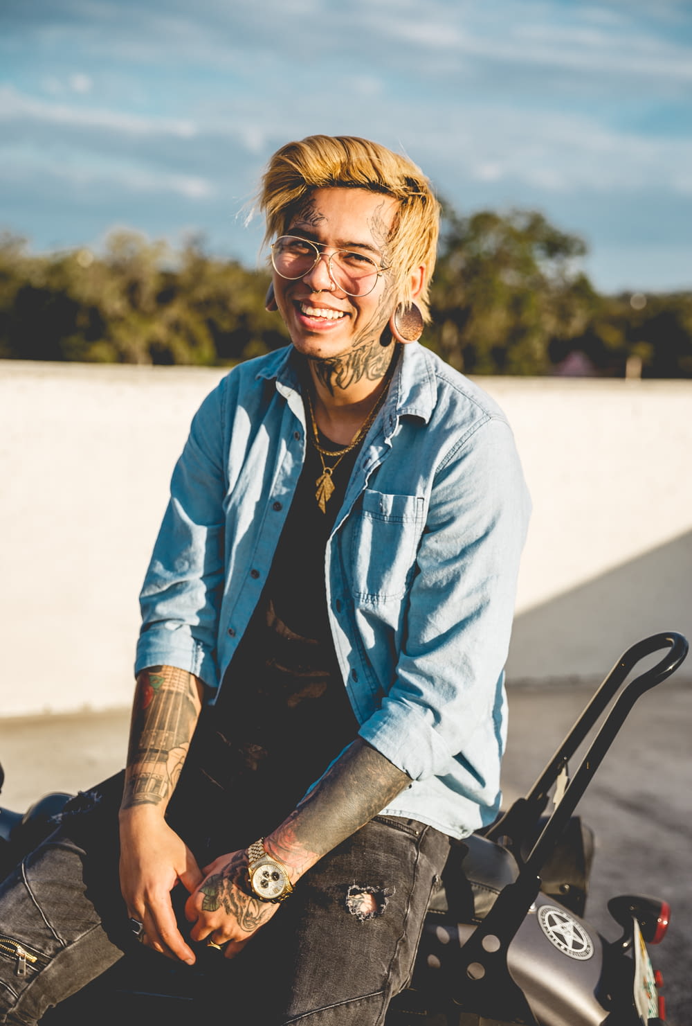 a man with tattoos sitting on a motorcycle