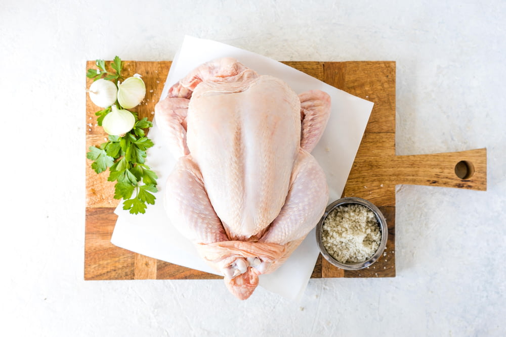 a raw chicken sitting on top of a cutting board