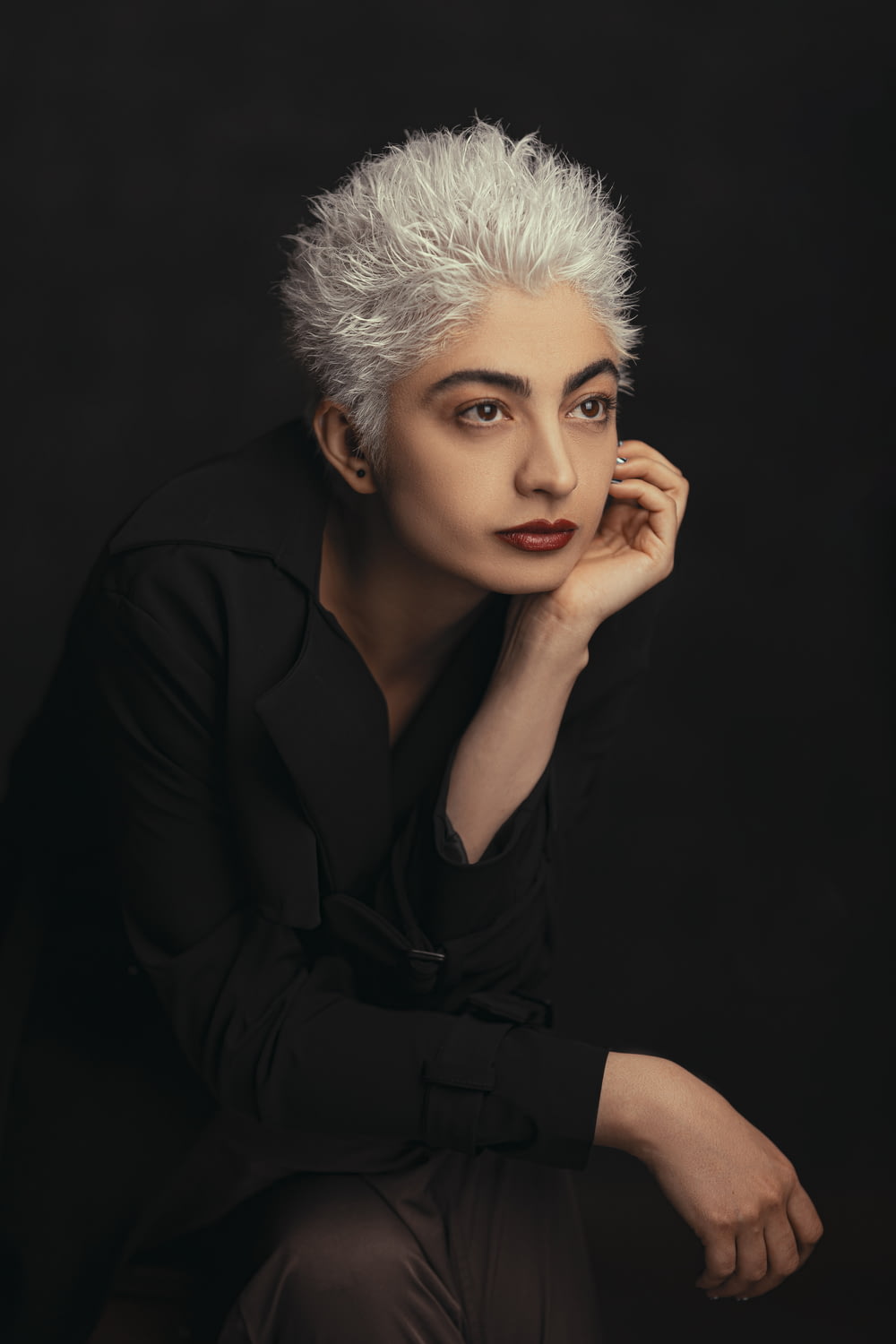 a woman with white hair and a black shirt