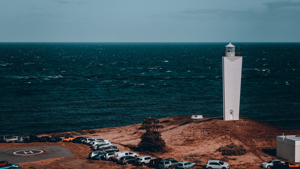 a lighthouse on top of a small island in the middle of the ocean