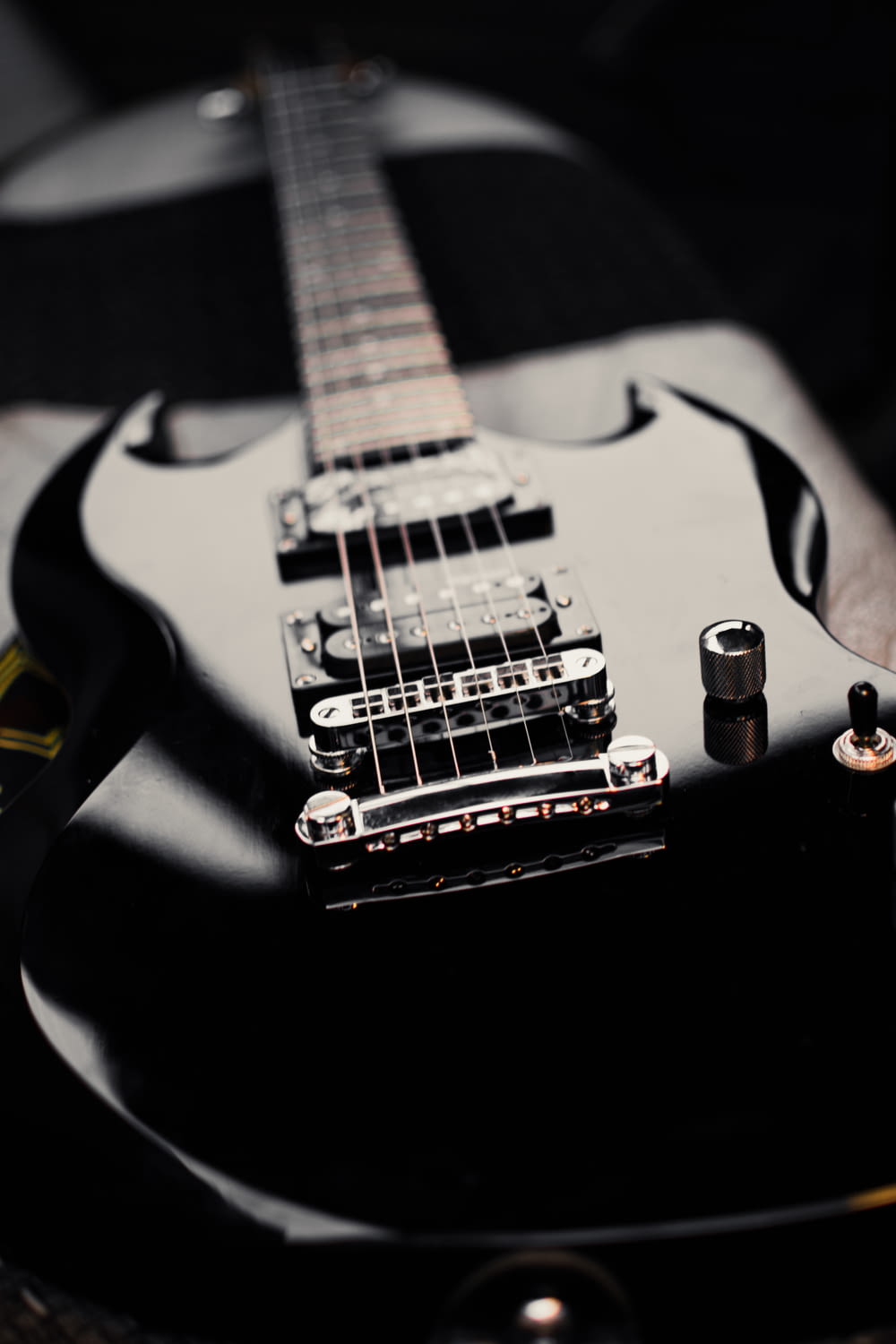 une guitare électrique noire posée sur une table