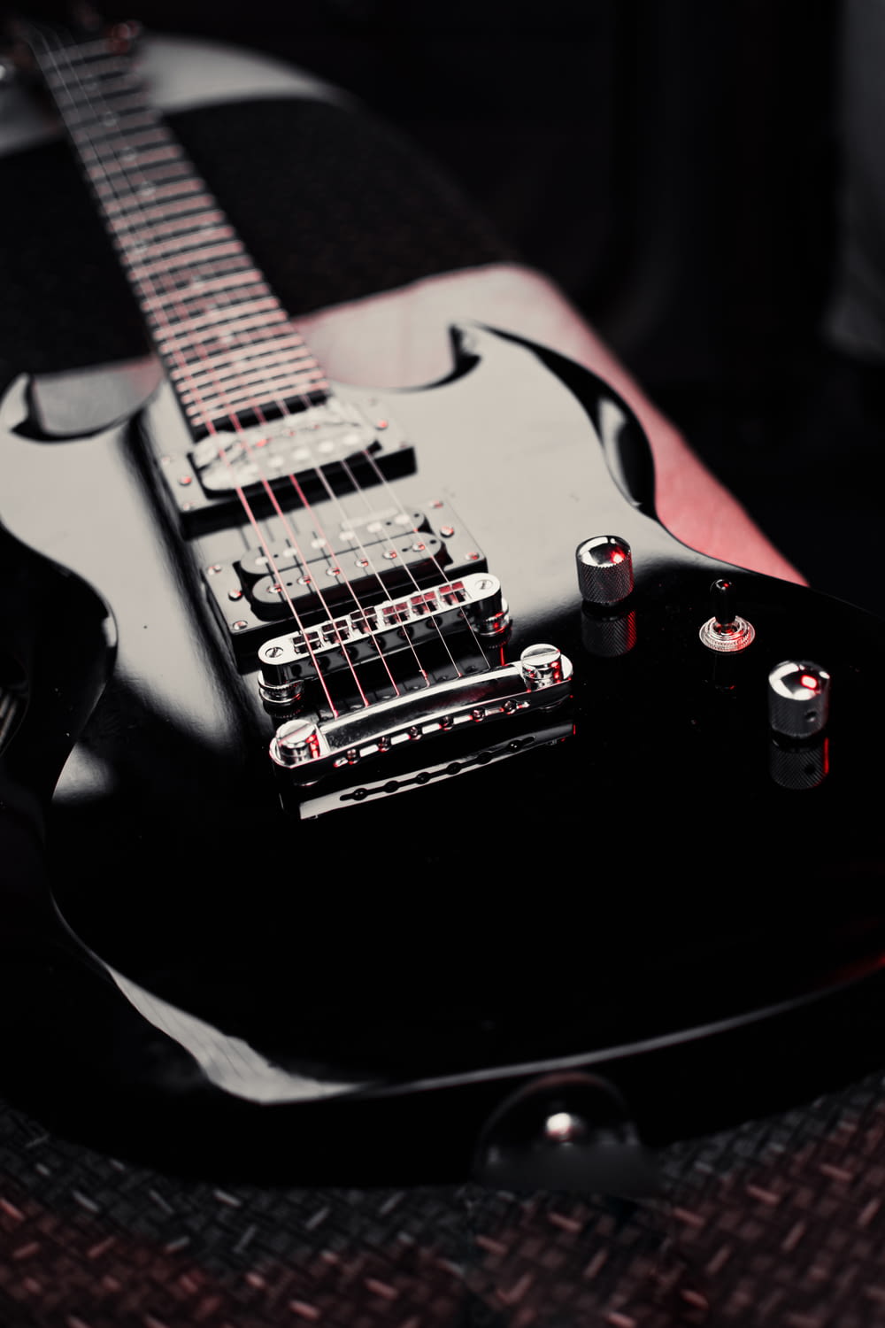 a black electric guitar sitting on top of a table