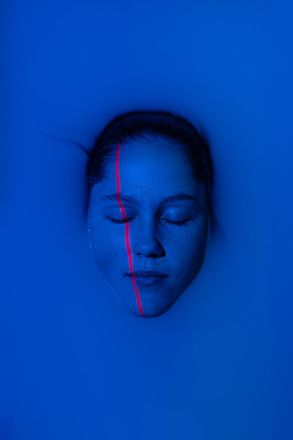 a woman with her eyes closed in a blue room