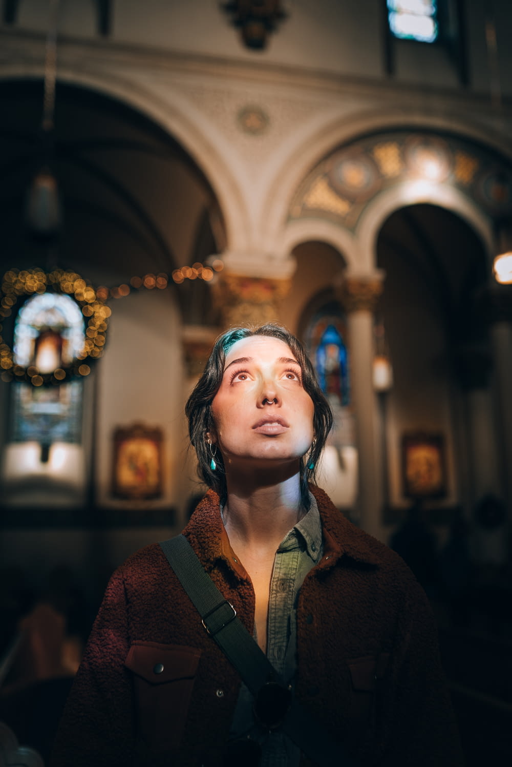 a woman standing in a church looking up
