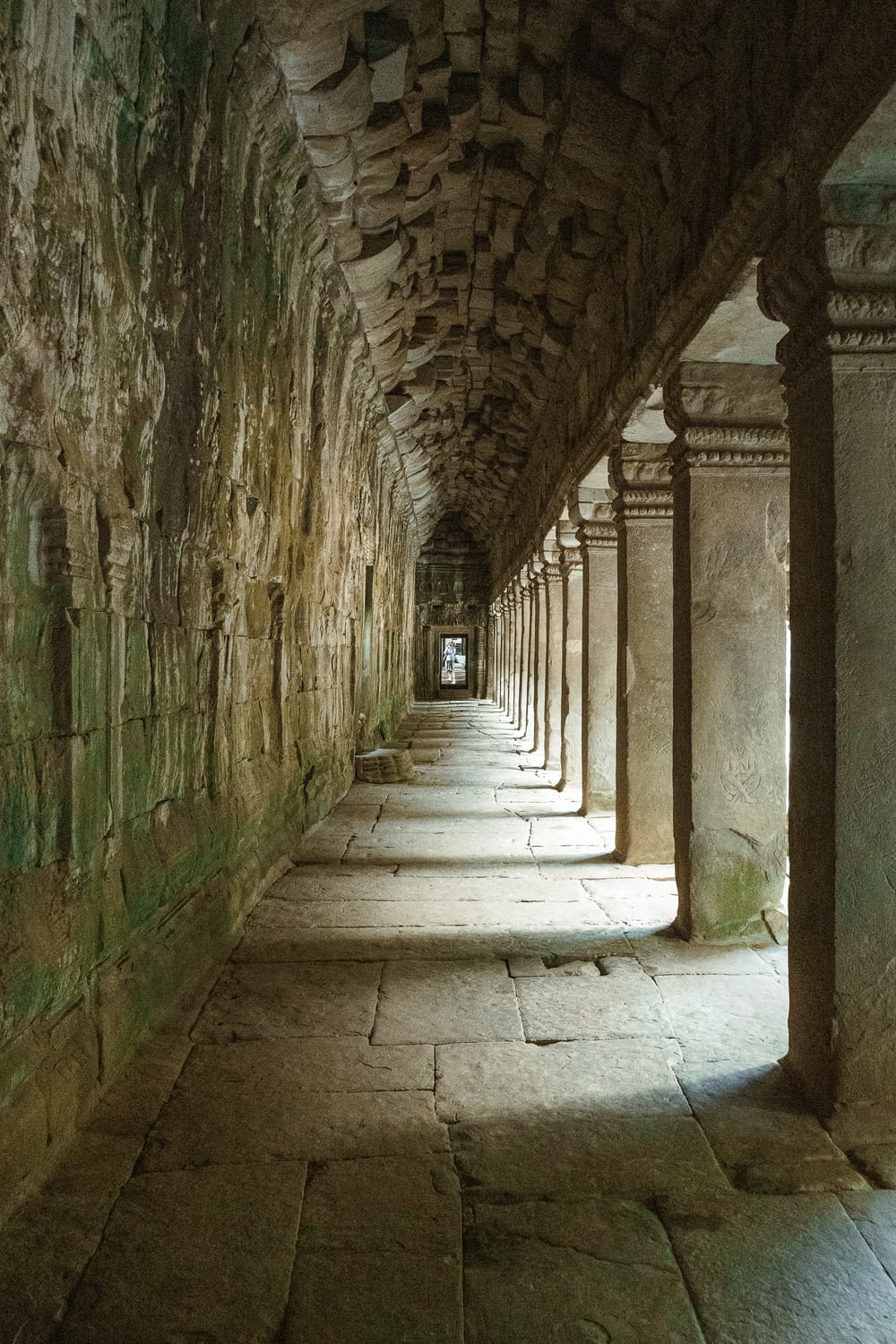 a long hallway with stone walls and pillars