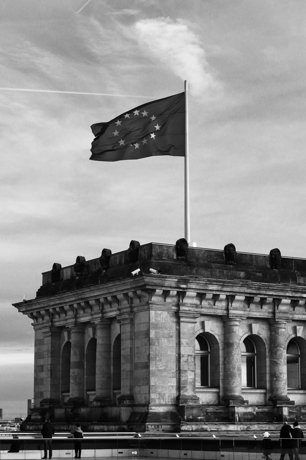 a black and white photo of a building with a flag on top