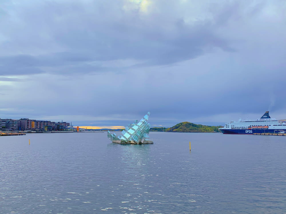 a large glass sculpture sitting in the middle of a body of water