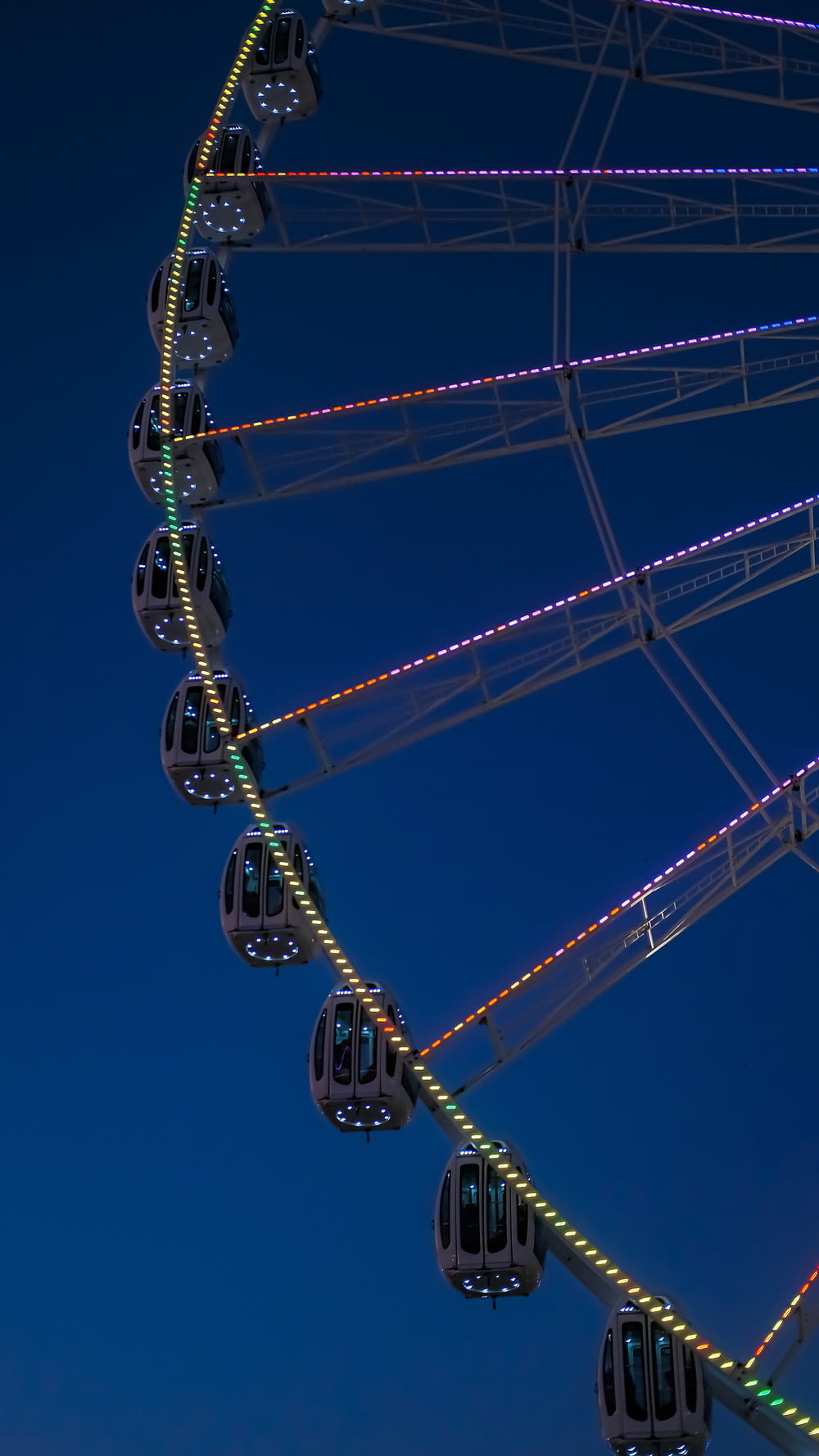 a ferris wheel lit up at night in the sky