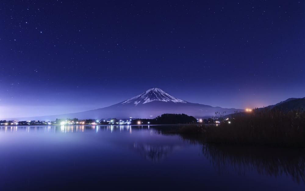 a night view of a lake with a mountain in the background