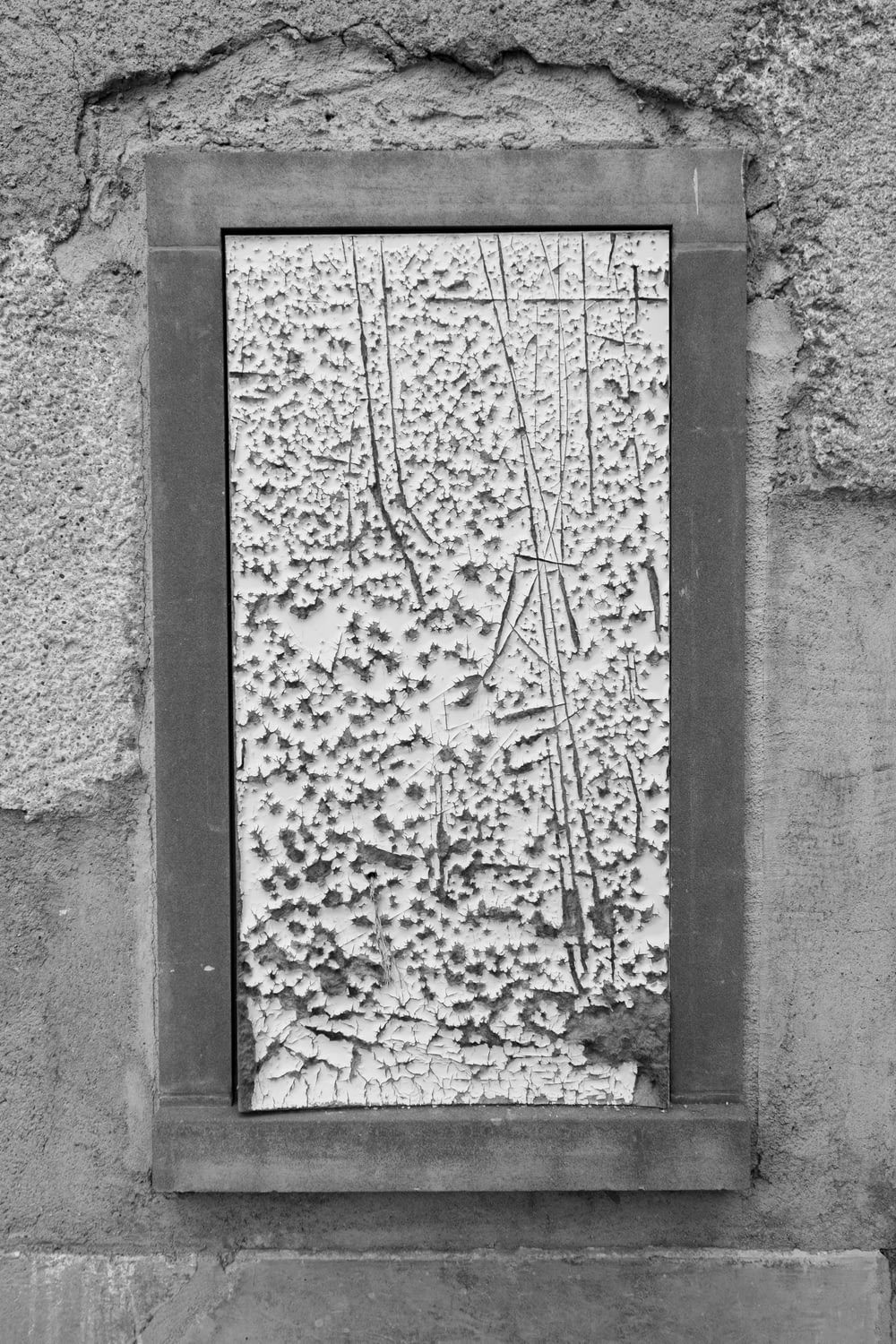 a black and white photo of a window in a wall