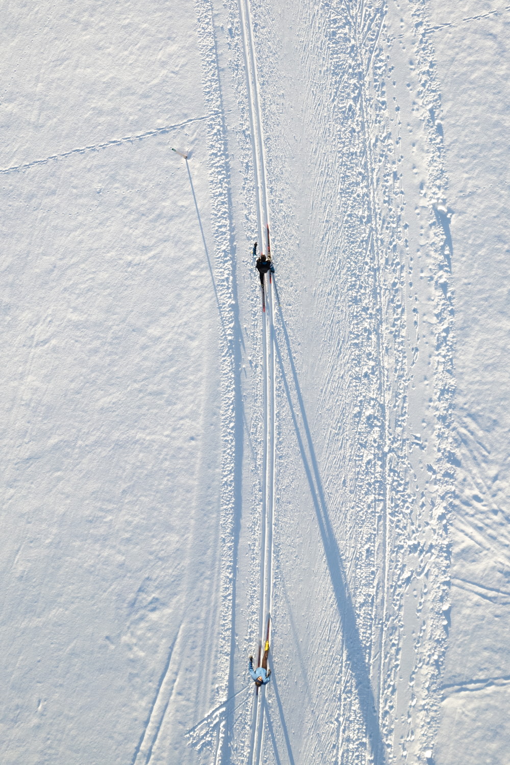 눈 덮인 슬로프에서 스키를 타는 두 사람