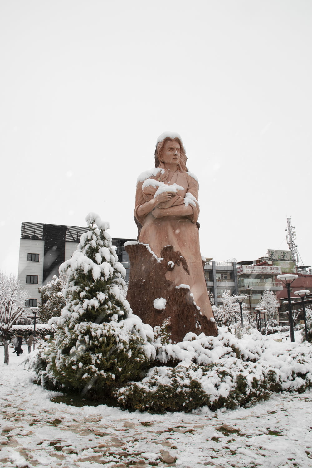 a statue of a woman is covered in snow