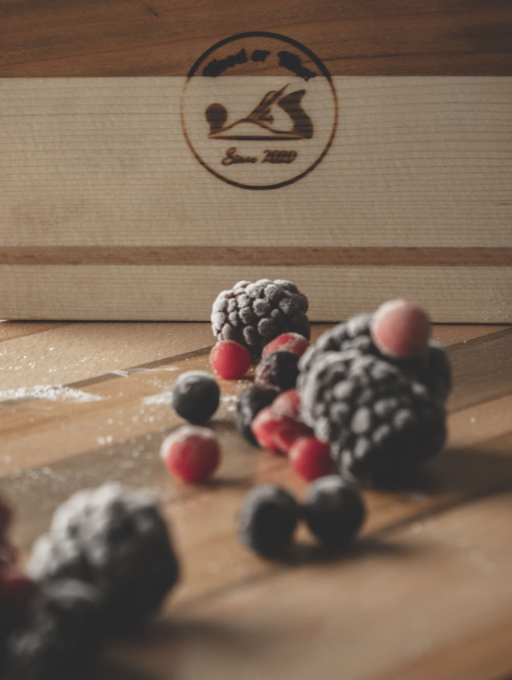 a wooden board topped with raspberries and blackberries