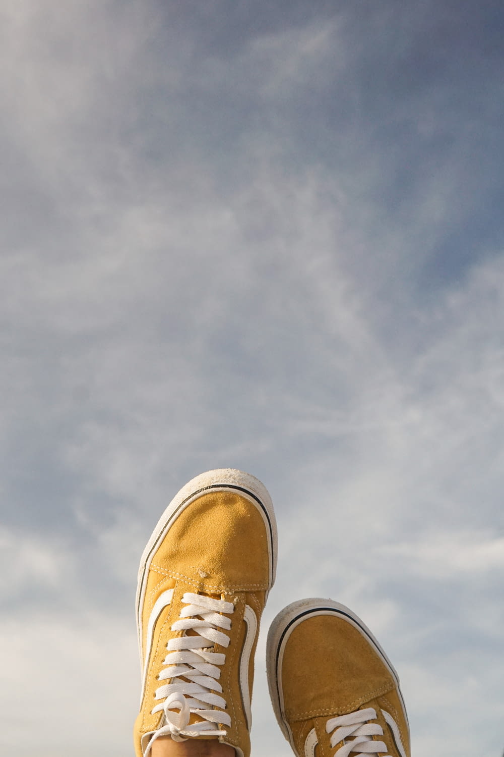 a person's feet with yellow shoes standing on a ledge