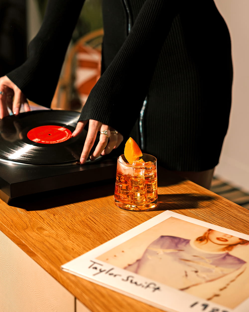 a woman is playing a record player on a table