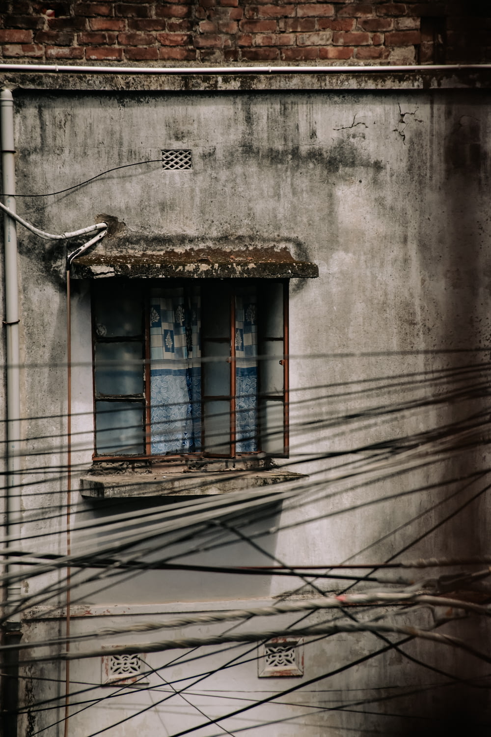 a building with a small window and wires in front of it