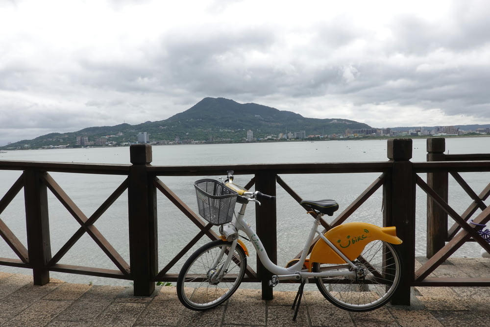 a bicycle parked next to a railing overlooking a body of water