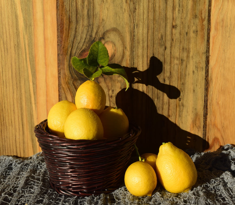 a basket full of lemons sitting on a table