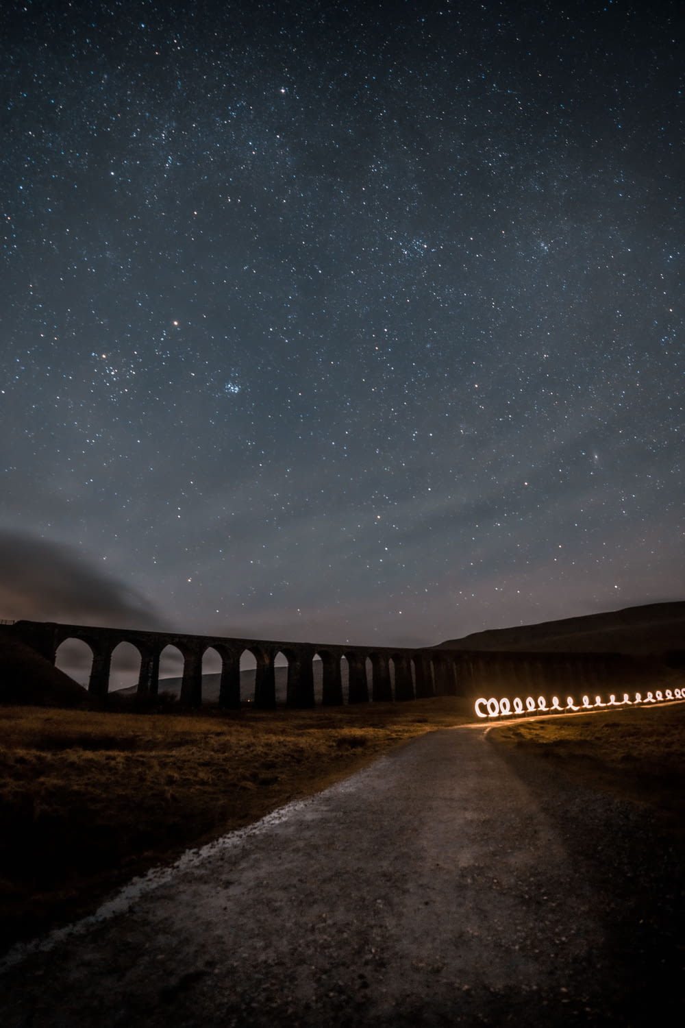 a train traveling over a bridge under a night sky