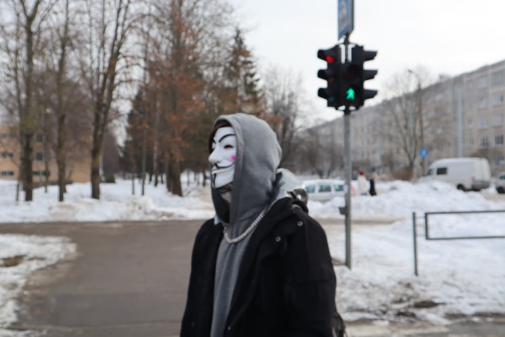 a person wearing a mask standing in the snow