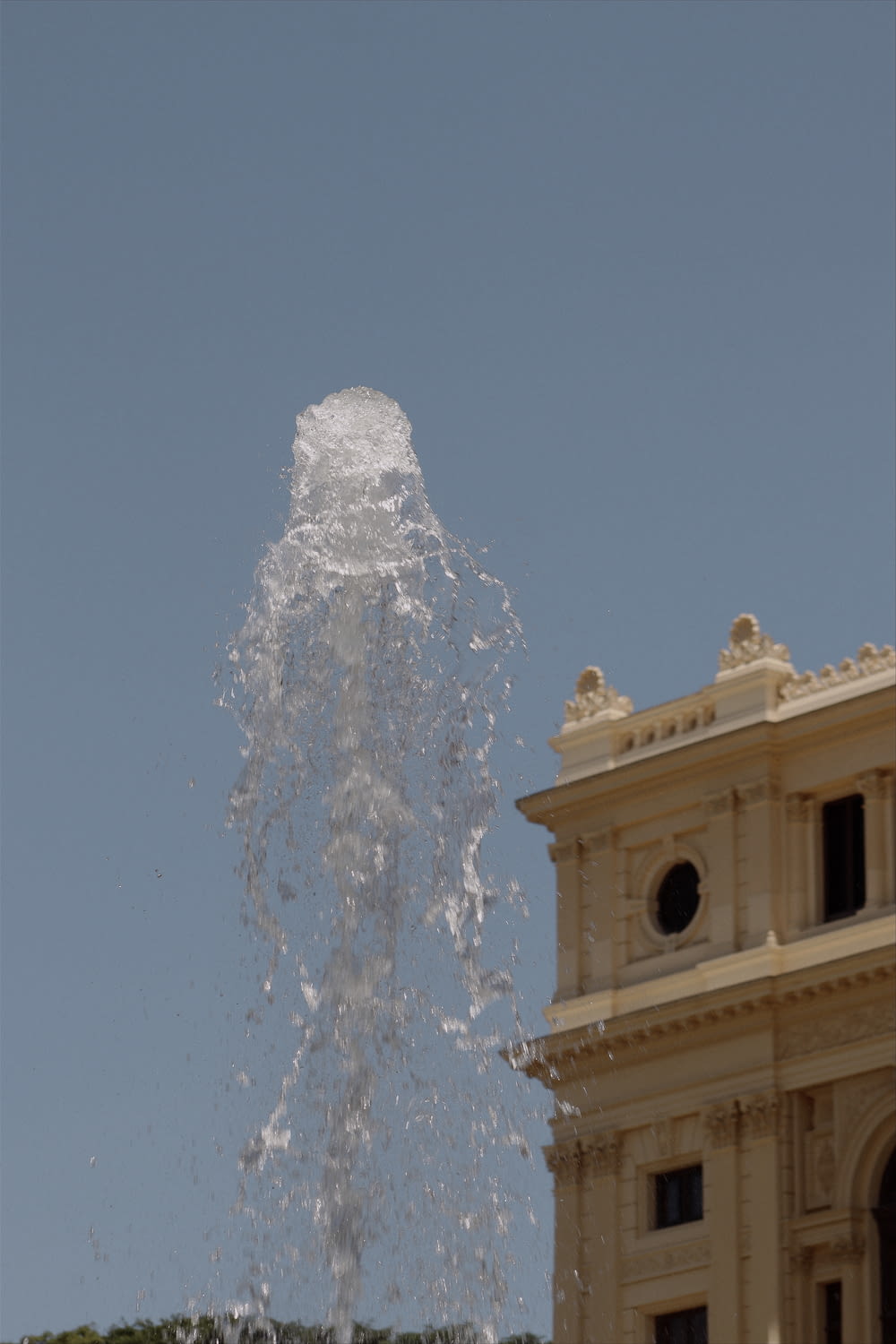 a large water fountain spewing out of the top of a building