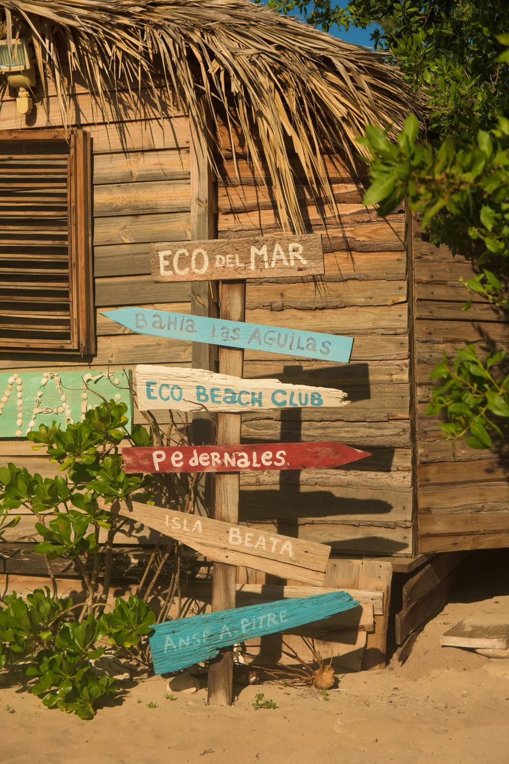 Un edificio in legno con un tetto di paglia e un cartello che dice Eco del Mar