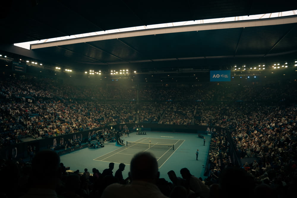 a crowd of people watching a tennis match