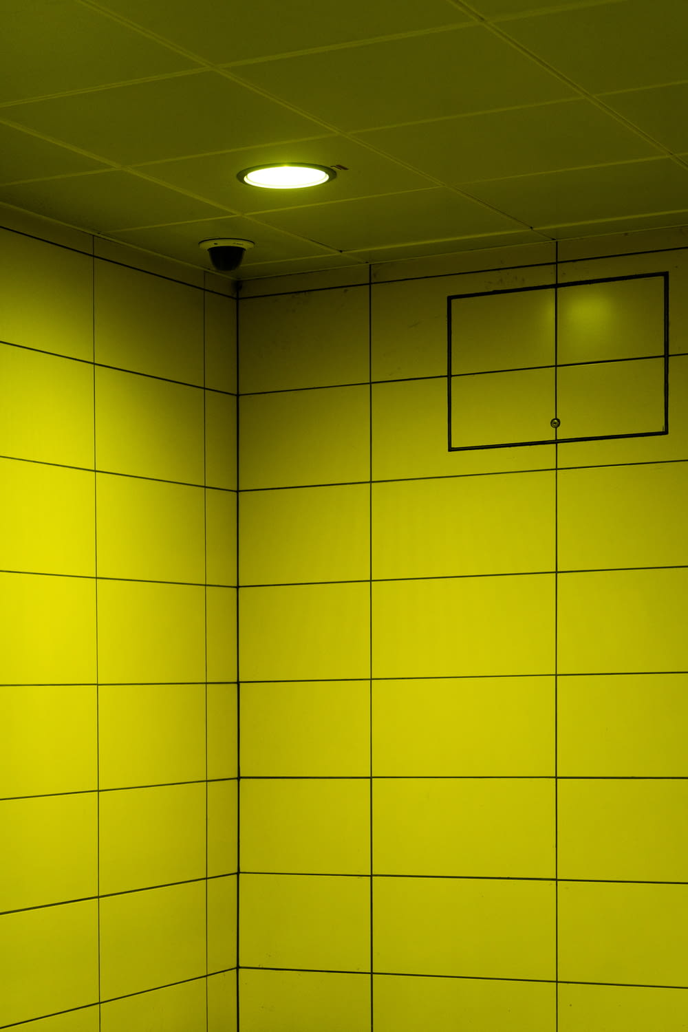 a bathroom with a yellow wall and a white toilet
