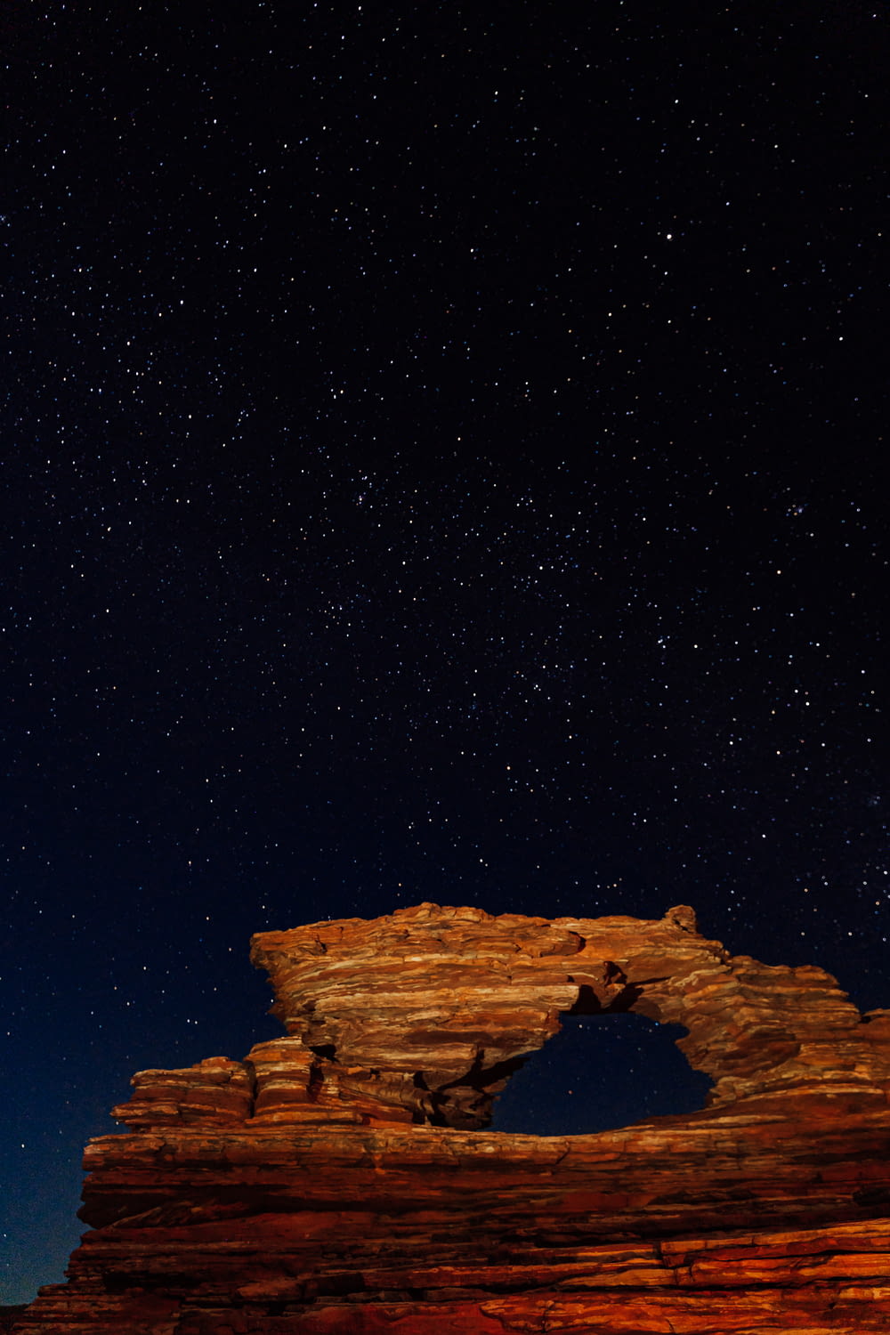 a rock formation under a night sky filled with stars